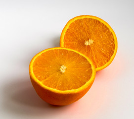 two halves of an orange on an isolated white background close up