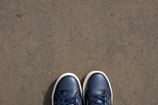 Feet In Blue Sneakers Standing On The Street-selfie Feet From A Personal Perspective - Asphalt Background With A Copy Of The Space