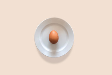 Egg puts on white plate for minimal food concept.