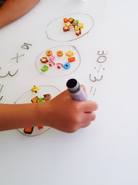 Cropped Hand Of Child Writing On Whiteboard