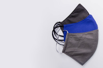 Close-up of three handmade medical masks of different colors, black, blue and gray isolated on a white background. The concept of scarcity of medical masks and the popularization of handmade masks.