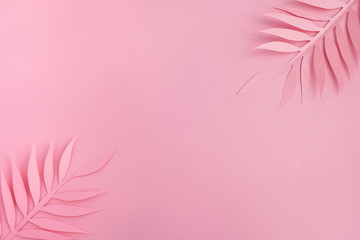 Paper palm leaves on light pink background. Minimal summer composition in pastel colors. Top view, flat lay, copy space