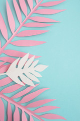 Fototapeta na wymiar Paper tropical leaves on mint background. Bright summer composition. Top view, flat lay, copy space