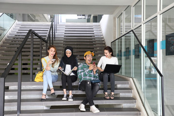 Young asian malay chinese man woman indoor stair corridor campus book file folder laptop computer phone sit stand mingle talk study