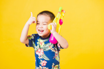little children boy so happy in Songkran festival day holding water gun