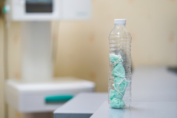 plastic bottle collected disposable of face mask waste before  garbage bin, infectious waste management.