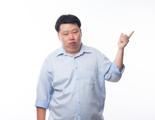 Asian Fat Man in blue shirt thinking and pointing to copyspace with doubts face isolated on white background.