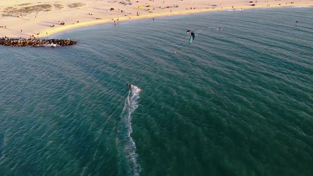 drone footage following a kitesurfer towards the beach