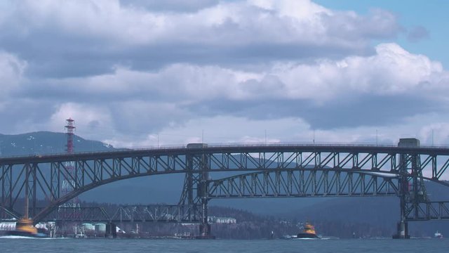 Time lapse of tugboats passing under the Second Narrows Rail Bridge. The Second Narrows Rail Bridge is a vertical-lift railway bridge that crosses the Burrard Inlet and connects Vancouver with the Nor