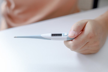 female hand holding a thermometer with high temperature. checking fever in Coronavirus  or Covid-19. patient from the Covid 19 Stay at home.