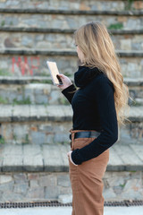 Young millennial woman using her cellphone  to browse internet and check her email and social media and connect with people