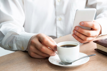 Man in white shirt using smartphone