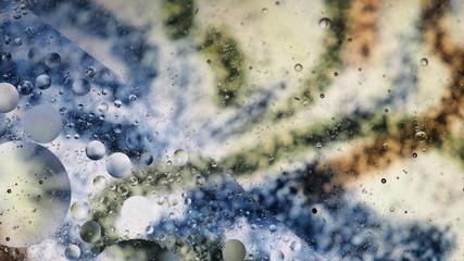 Mixing water and oil, beautiful colors. Close-up. Abstract background of filaments of different colors. Water and oil bubbles. Abstract light illumination