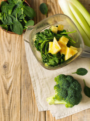 Ingrediets for green smoothie - parsley, spinach, broccoli and celery on wooden table