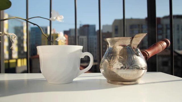 Morning coffee.Beautiful view of the city.Coffee in an ibrik and flower Orchid.