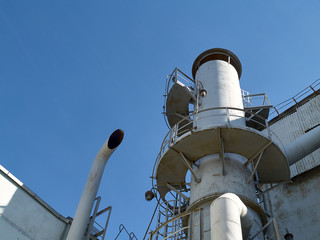 Bright air separation plant pipes and lanterns at bright sunny day over clear deep blue sky...
