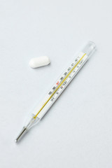 a thermometer and pills close up