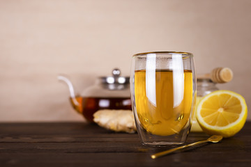 Antioxidant healthy green tea with lemon, ginger and honey on a wooden table. Immune system booster food.