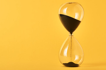 Hourglass on the yellow background with copy space. Concept of running out of time and deadline
