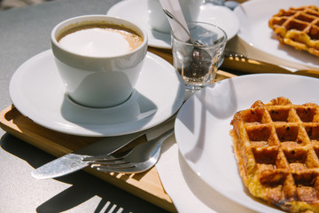 A couple of Liege Waffles with 2 cups of cappuccino at a city Cafe in Ghent. 