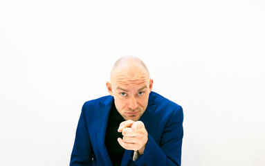 Male person in blue jacket points finger and looks seriously . Judgement and commitmet concept.   White background blank space image.