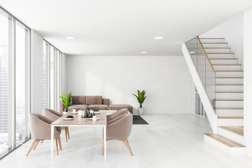 White dining room interior with sofa and stairs