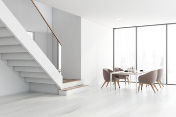 Panoramic white dining room corner with stairs