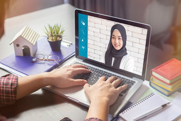 Asian Muslim woman talking colleagues about plan life in video conference. Multiethnic business team laptop online meeting in video call.smart working from home, quarantine from coronavirus covid-19