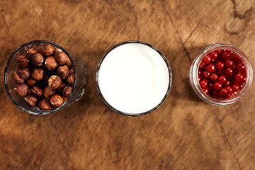 Yogurt with nuts on a wooden light background. View from above. Natural yogurt.