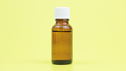 Medicine bottle of brown glass isolated on yellow background, (clipping work path included).
