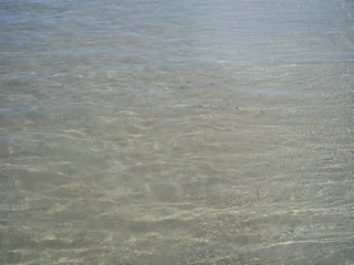 Coastal the bottom of small pebbles through the clear water.