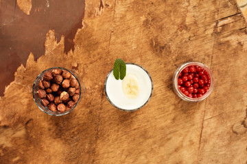 Yogurt with nuts on a wooden light background. View from above. Natural yogurt.