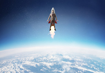 Obraz na płótnie Canvas Businessman in aviator hat flying on rocket