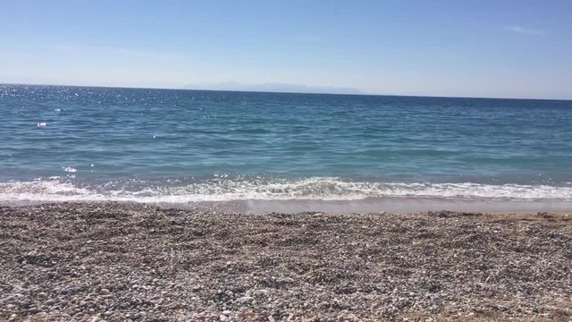 Glyfada Marina, Greece - 20th March 2018 : Peaceful and blue sea wave on the beach in Athens