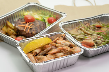 Close-up of a ready meal for delivery and a paper bag on a white background.