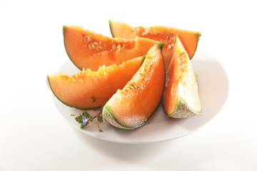 melon slices on plate isolated on white background
