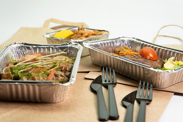 Delivery of delicious healthy food in foil boxes. Concept of food delivery in quarantine, self-isolation. © Katy_81
