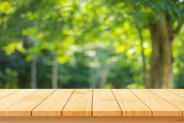 Empty wood table top on blur abstract green from garden 
