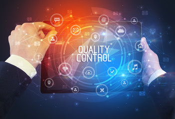 Close-up of a tablet with QUALITY CONTROL inscription, innovative technology concept