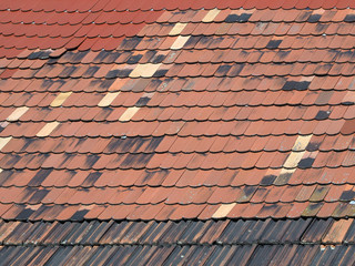 Repariertes, geflicktes Ziegeldach aus verschiedenen Dachziegeln