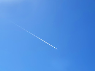 The white path of aircraft in the blue clear sky.