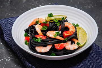 Squid Ink Pasta with Prawns , Tomatoes, Lemon and Herbs. Black Spaghetti, Black Organic Noodles . Mediterranean Gourmet Food