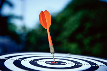 Bullseye(bull's-eye) or dart board has dart arrow hitting the center of a shooting target for...