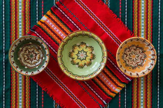 2017 October - Bulgaria, Balchik - traditional Bulgarian piyalas made in Troyan technique on traditional table clothes of red and green colors.