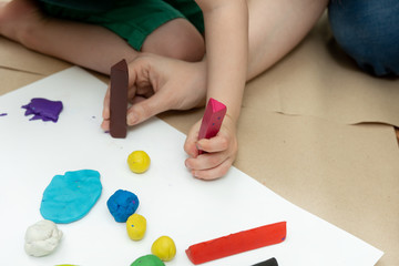 pieces of plasticine in children's hands. creativity, leisure at home and at school