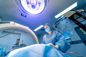 Process of surgery operation using medical equipment. Operating room with X-ray medical scan.