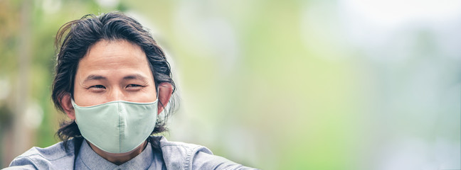 Business man wearing a cloth mask in public area protect himself from risk of disease, people prevent infection from coronavirus Covid-19 or Air pollution with copy space area wide banner bacground