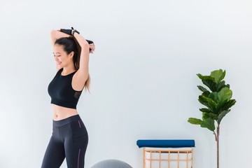 Asian beautiful women warm up and  play yoga and stretch body before exercise on white wall background with copy space.Exercise for Lose weight, increase flexibility and tighten the shape.