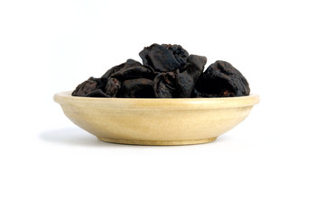 Closeup garcinia cochinchinensis (called Asam kandis in Indonesia) on wooden plate isolated white background