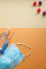 Protective face masks, thermometer and hand  sanitizing gel bottle on neutral background. Concept of coronavirus pandemic. Virus and COVID-19 self protection.